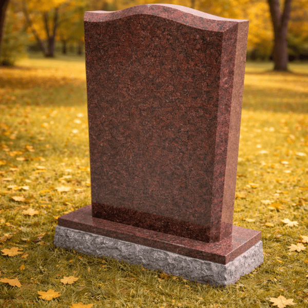 Tall red granite monument headstone with polished surface in cemetery
