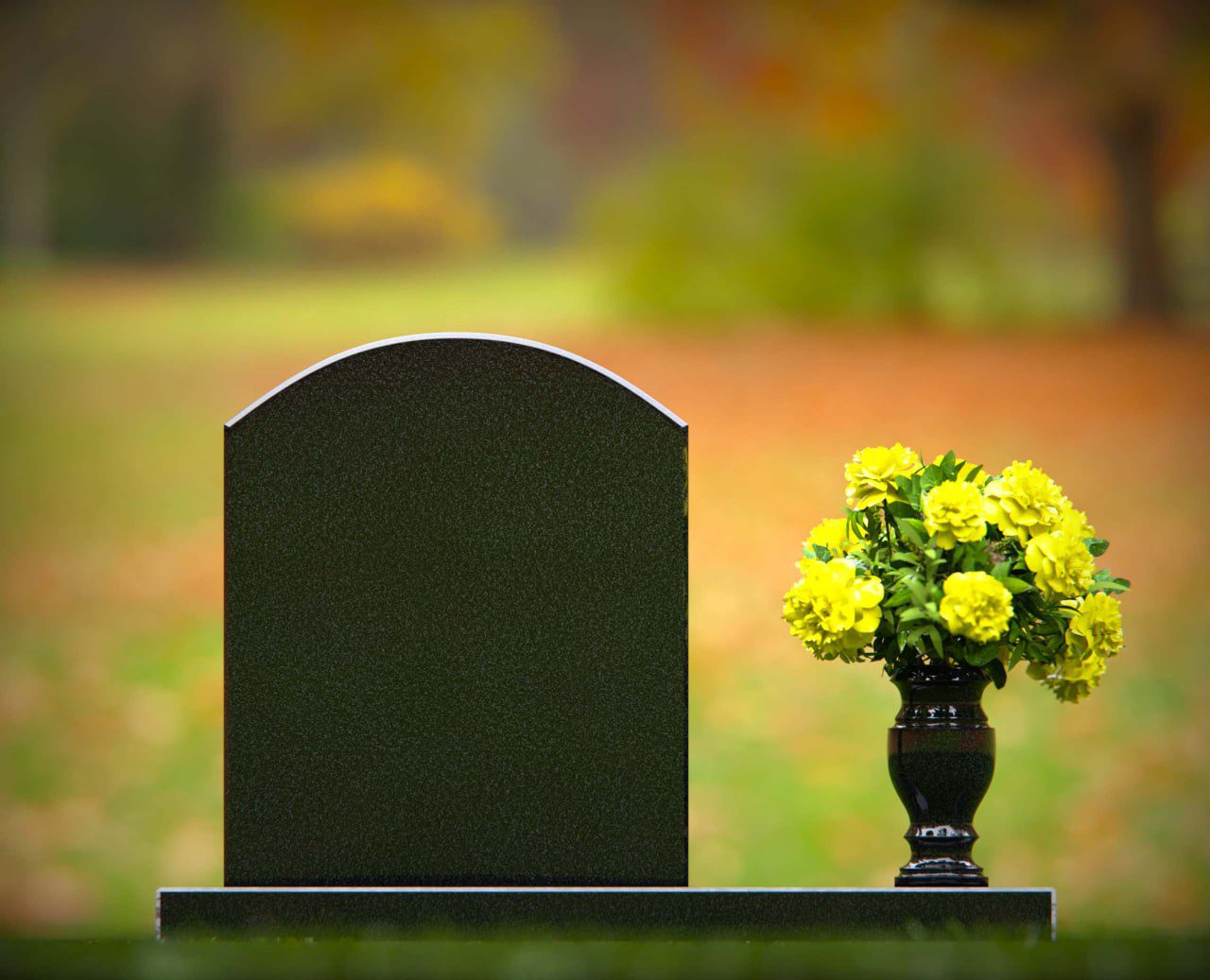 green-granite-headstone-with-vase Upright green granite headstone with flower vase in cemetery