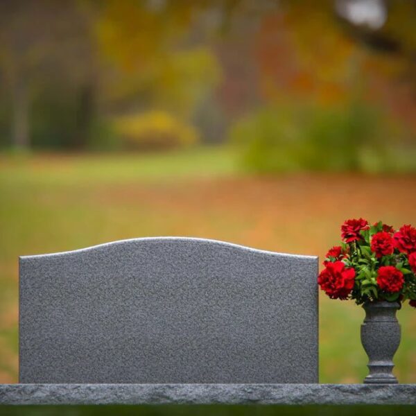 Flat gray grave marker with vase in cemetery setting by Memory Stones